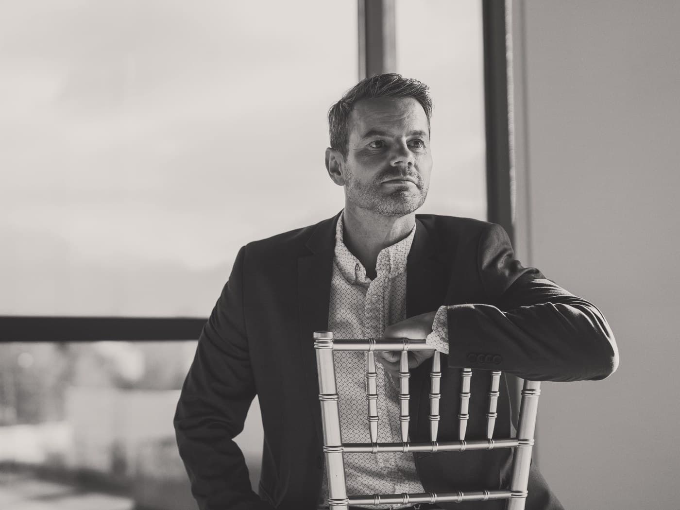 Ben Tracy, MD, leaning on the back of a chair in the Draper clinic.