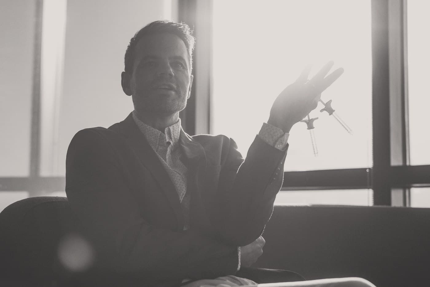 Ben Tracy, MD, mid conversation in the clinic, holding two prepared syringes.